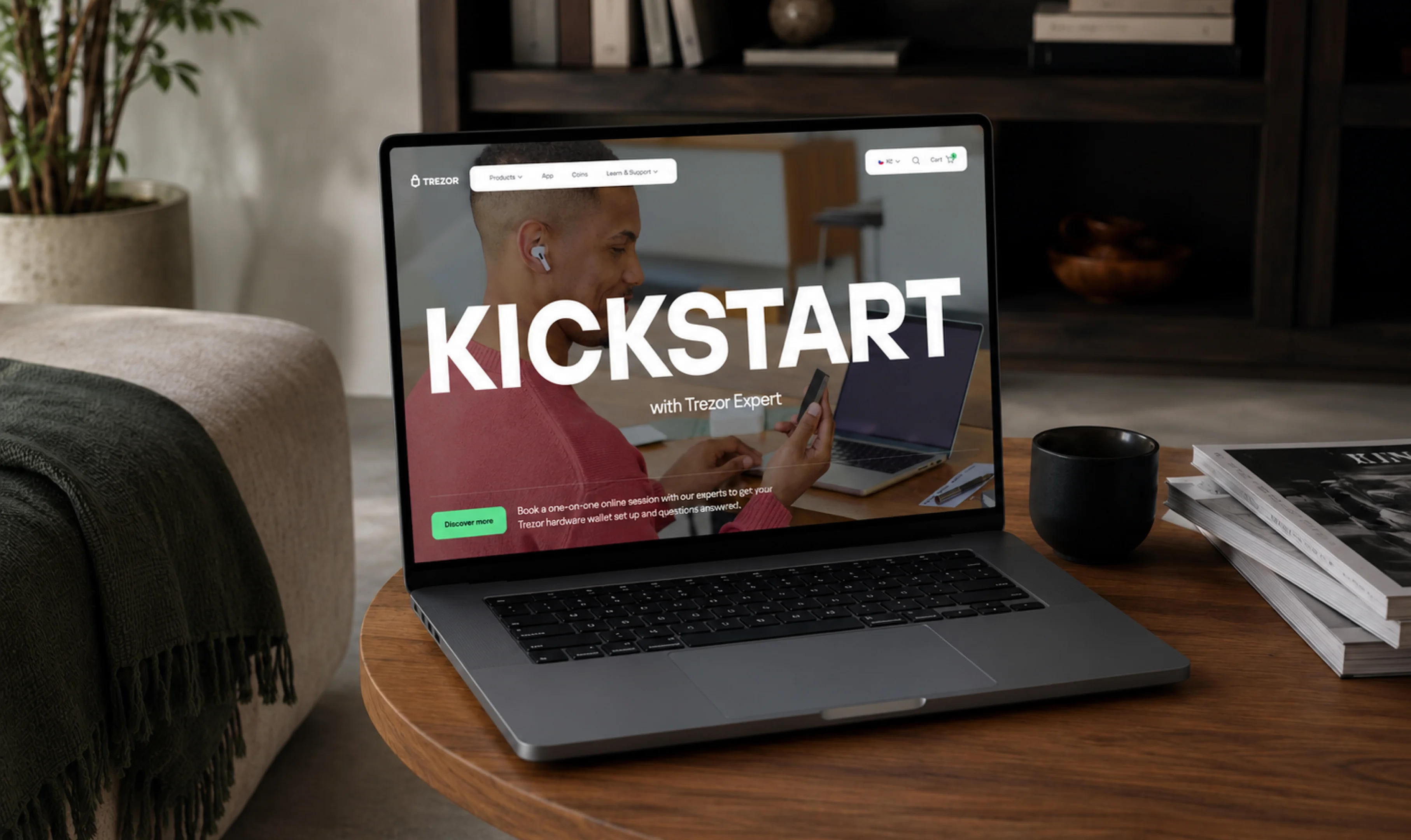 A laptop on a wooden desk showing the “Kickstart with Trezor Expert” campaign page.