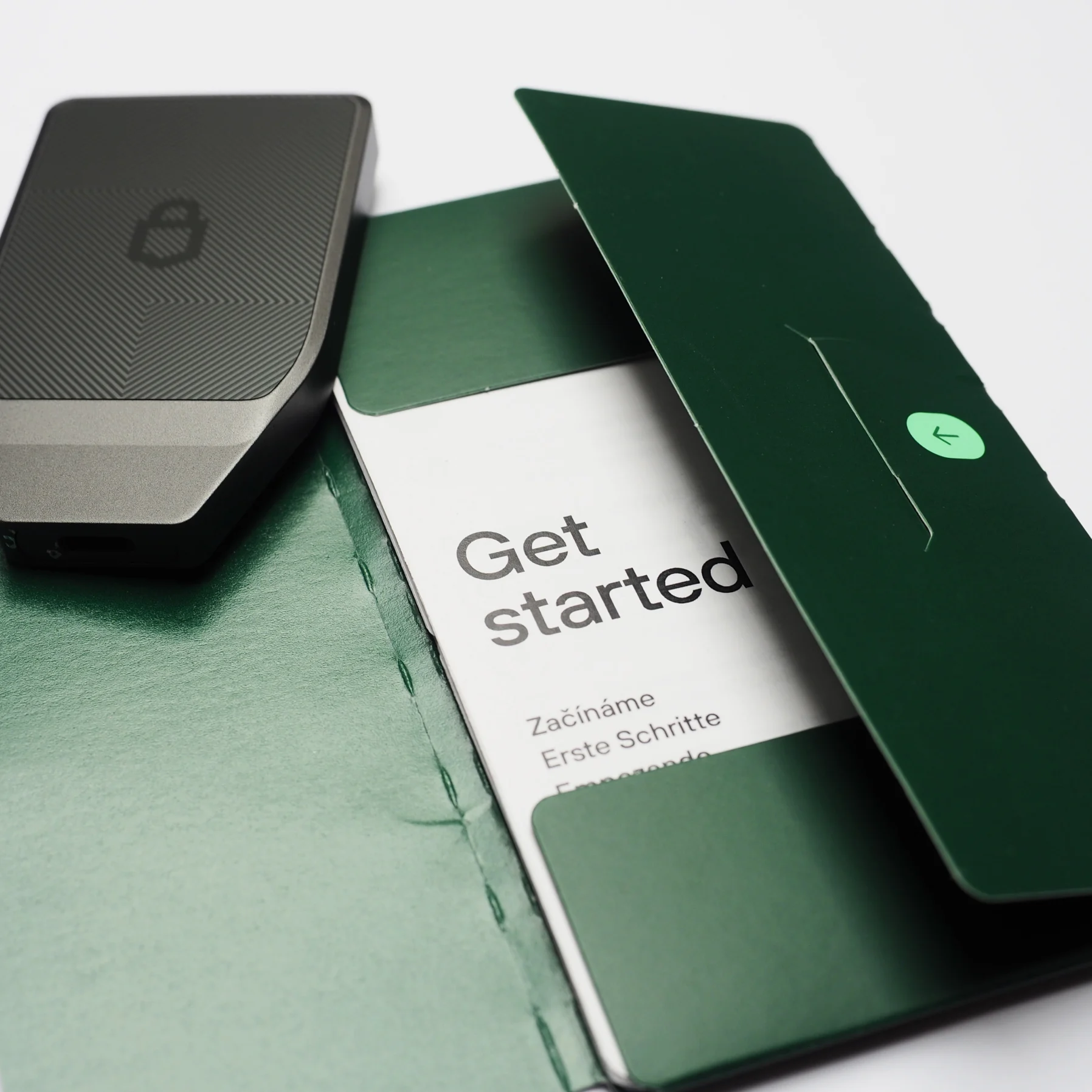 The graphite Safe 7 resting beside its green “Get started” sleeve, shot close.